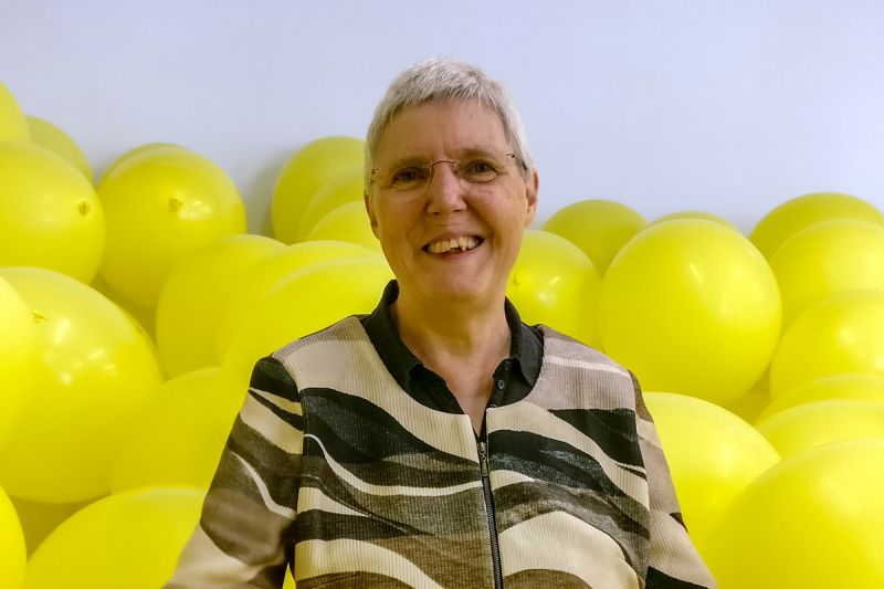 Dr. Mechthild Müller-Hennig in einem Raum voller gelber Luftballons